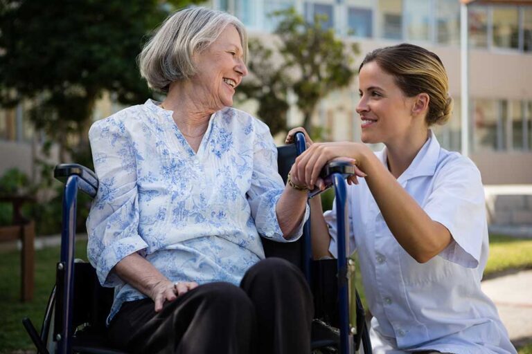 Family members review assisted living information beside a senior at a table with notes and a tablet.