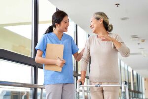 Social worker speaking with an older resident and family member at a table in an assisted living apartment