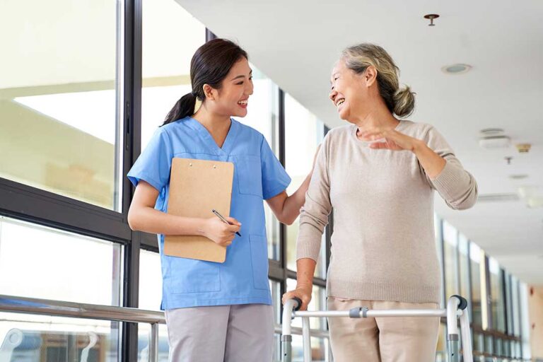 Social worker speaking with an older resident and family member at a table in an assisted living apartment